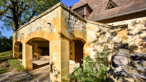 A stone building with arches, a staircase, and a tree in the background. - Pool Escape in Saint-laurent (Saint-Laurent-la-Vallee)