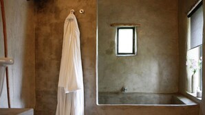 A bathroom with a large bathtub, a small window, and a towel hanging on the wall. - Luxurious Farmhouse in Braize (Braize)