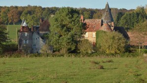 A historic building with a prominent tower, surrounded by trees and a grassy field. - Luxurious Farmhouse in Braize (Braize)