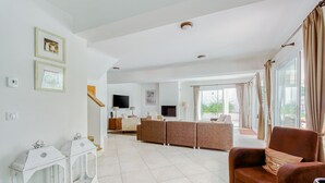 A spacious living area with a sofa set, a television, and a dining table. - Villa in Le Muy With Private Pool & Forest (Le Muy)