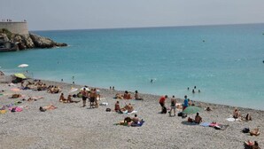 A beach with people sunbathing and swimming, a rocky structure, and a clear sky. - Villa in Le Muy With Private Pool & Forest (Le Muy)