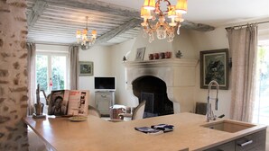 A kitchen with a large island, a fireplace, and a chandelier. - Mas in Eygalieres With Heated Pool (Eygalieres)