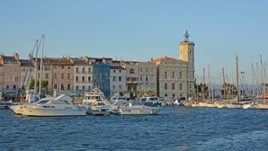 A marina with boats docked, a prominent tower, and buildings with balconies. - Mas in Eygalieres With Heated Pool (Eygalieres)
