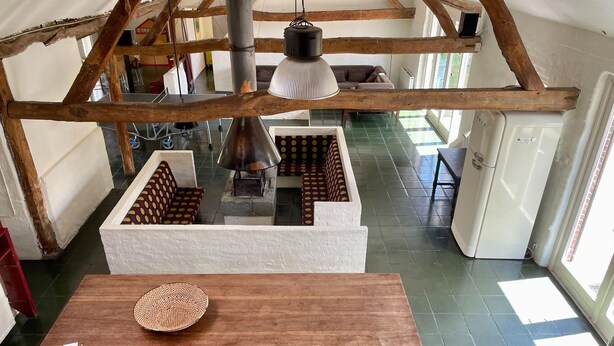Une pièce avec une table en bois, un panier en osier et une grande lampe.