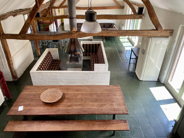 A room with a wooden table, a woven basket, and a large lamp.
