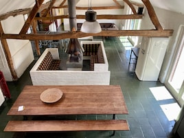 A room with a wooden table, a woven basket, and a large lamp.