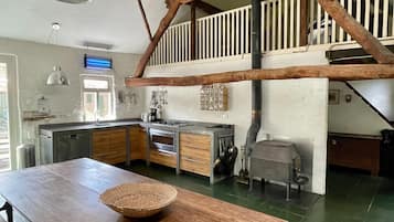 A kitchen with wooden cabinets, a large island, and a hanging pot rack.
