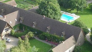 A large building with multiple windows, a swimming pool, and surrounding greenery. - Holiday Home in Quend-plage Near Lake (Quend)