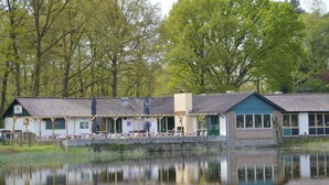 En bygning ved søen med en overdækket terrasse og udsigt over vandet.