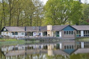 A lakeside building with a covered patio area and a view of the water.