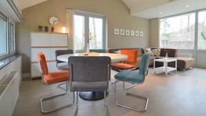 En moderne stue med et rundt spisebord, to sofaer og et sofabord.