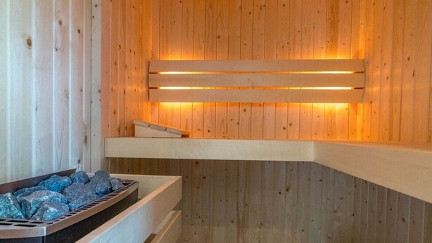 Un sauna en bois avec des bancs et un mur chauffant.