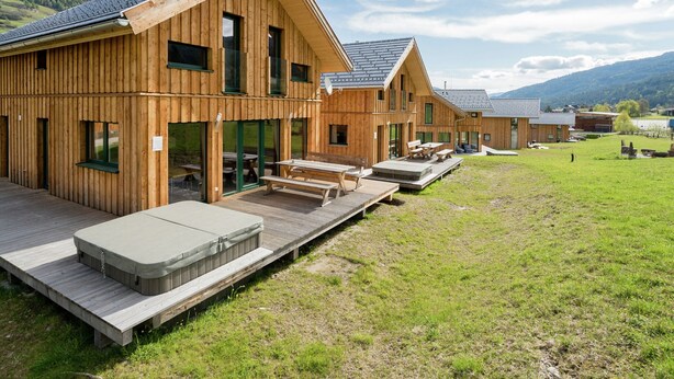 Eine Holzhütte mit mehreren Zimmern, Außenbereich und einem Whirlpool.