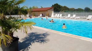 A swimming pool with lounge chairs and a covered area. - Apartment in Faverolles Near the Beach (Villentrois-Faverolles-en-Berry)