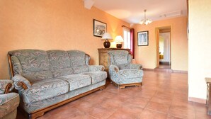 A living room with a sofa, armchair, and lamps. - Apartment in Faverolles Near the Beach (Villentrois-Faverolles-en-Berry)