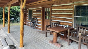 A log cabin with a porch, wooden benches, a wheelchair, and a sign reading "CABIN". - Holiday Home With Garden in Den Ham (Den Ham)