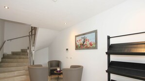 A modern living room with a staircase, a sofa set, and a piano. - Luxurious Apartment in Fugenberg With Balcony (Fuegenberg)