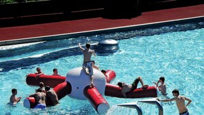 A swimming pool with inflatable structures and people swimming and playing. - Luxurious Apartment in Fugenberg With Balcony (Fuegenberg)