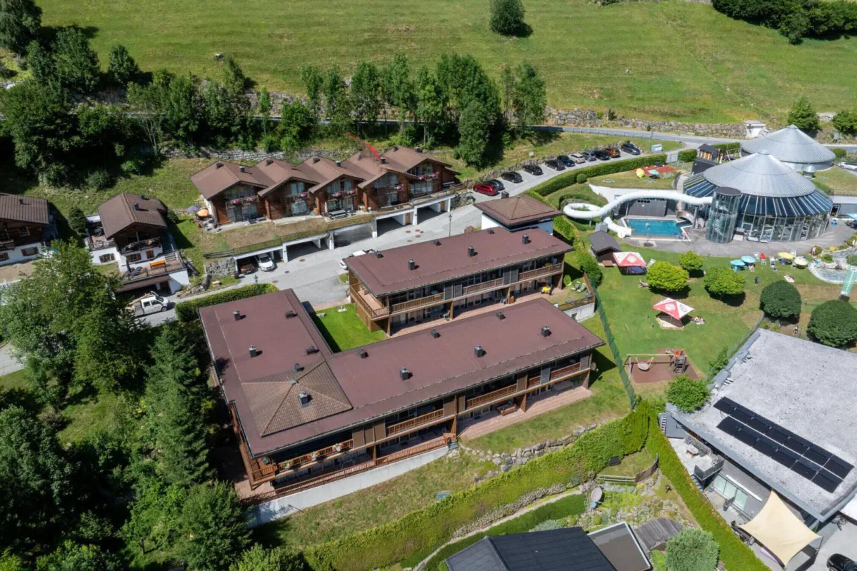Un gran complejo hotelero con varias construcciones, piscina y un espacio al aire libre cubierto.