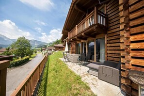 A wooden cabin with a balcony, outdoor seating, and a view of mountains. - Scenic Alpine Chalet in Wald im Pinzgau (Wald im Pinzgau)