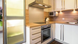 A modern kitchen with a built-in oven, microwave, and stainless steel range hood. - Apartment in Leogang Near Ski Slopes (Leogang)