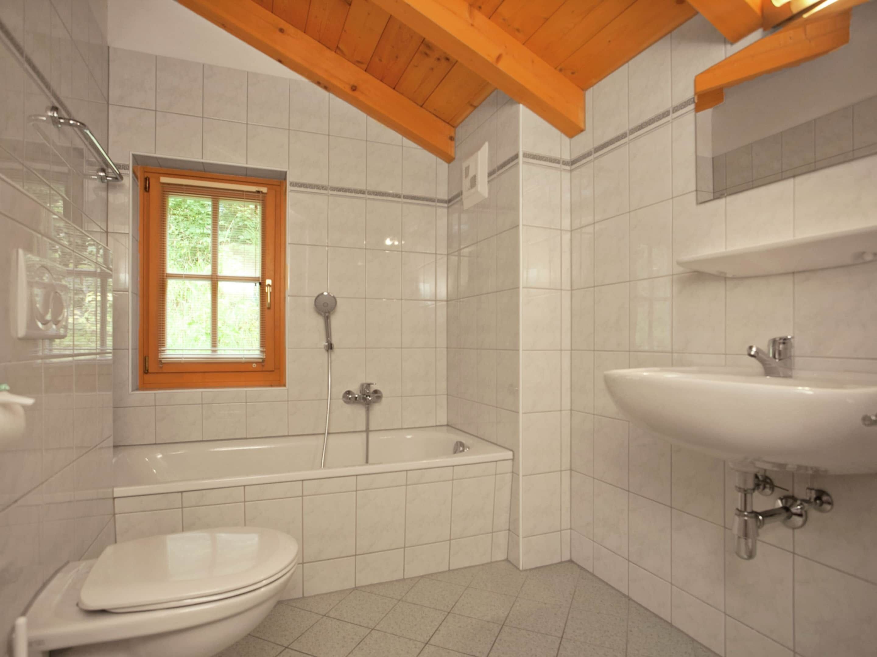 A bathroom with a toilet, a bathtub, and a sink.