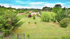 A grassy area with trees and a fence, likely a garden or park. - Holiday Home Talairan With Pool and BBQ (Talairan)