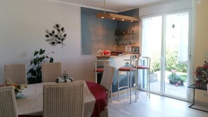 A dining area with a table, chairs, and a kitchen counter in the background. - Peaceful Forest Stay in Pedernec (Pedernec)