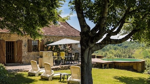 A stone building with a patio, outdoor seating, and a swimming pool. - Holiday Home in Dordogne With Private Pool (Thenon)