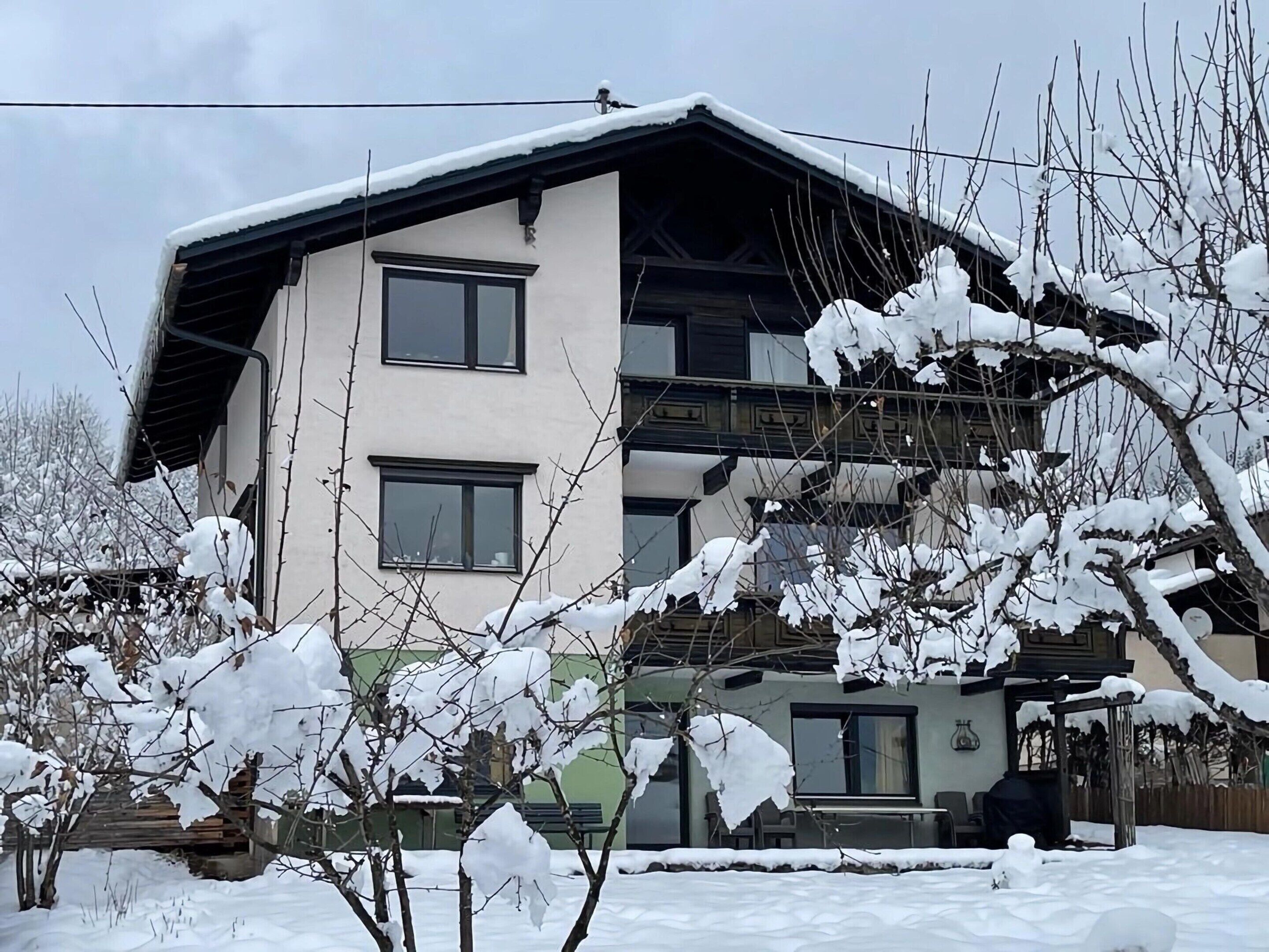 A two-story building with a sloped roof, multiple windows, and a balcony.