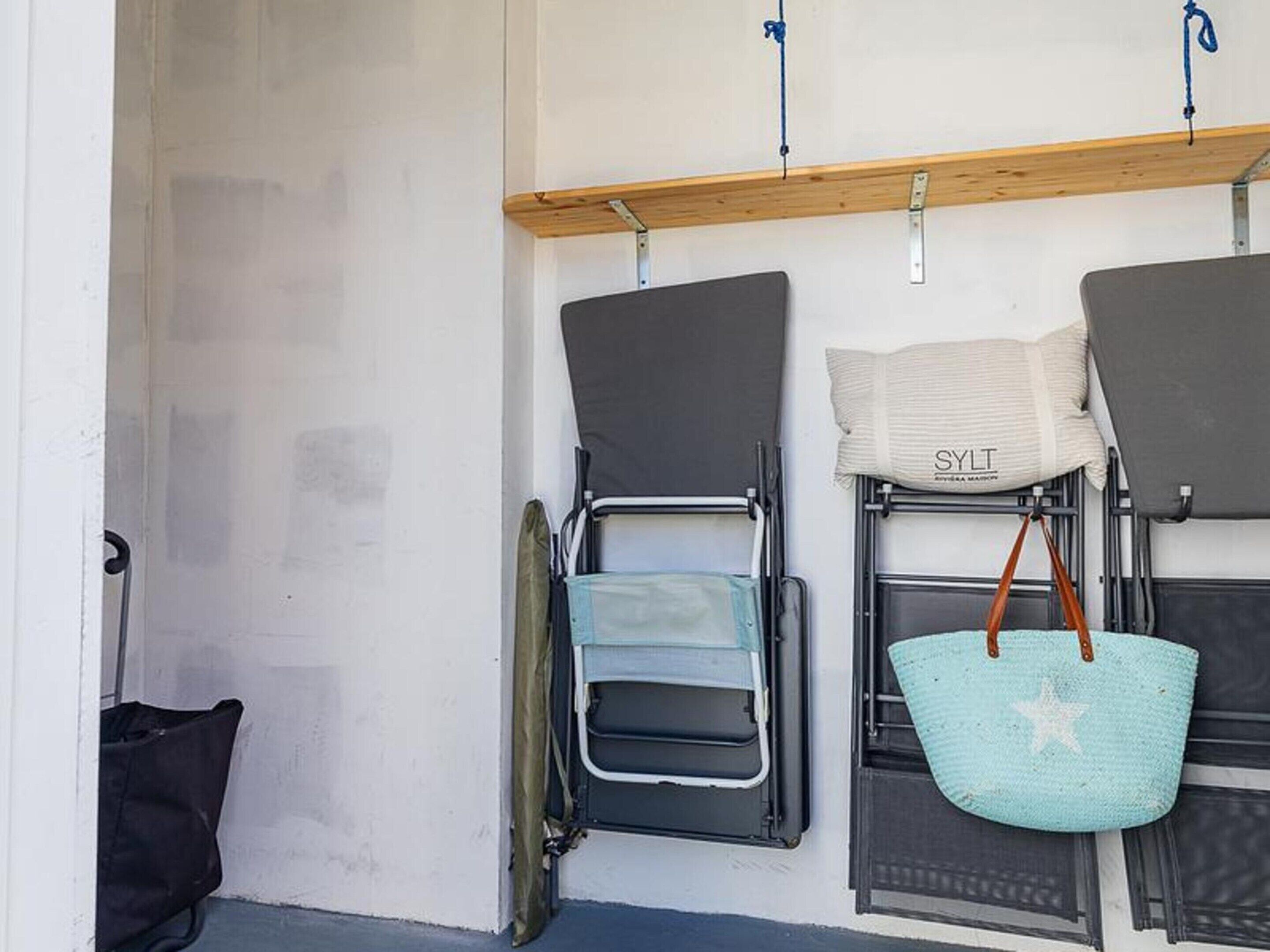A room with a bed, a chair, a small table, and a window.