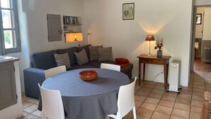 Un salón acogedor con una mesa redonda, un sofá y un radiador.