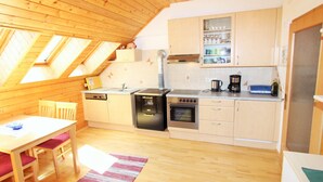 Una cocina compacta con armarios de madera, una estufa y un lavavajillas.