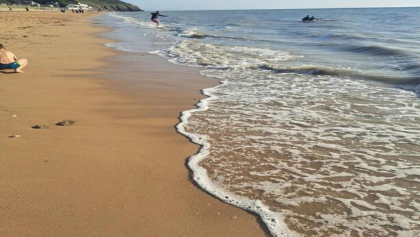 A beach with a sandy shore, waves, and a person surfing. - Peaceful Stay Near Lake (Isigny-le-Buat)