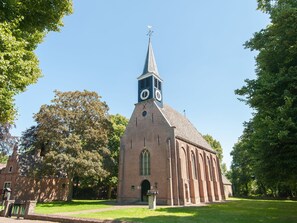 A church with a clock tower, brick construction, and a clear sky. - New Holiday Home near Beach of Petten (Petten)