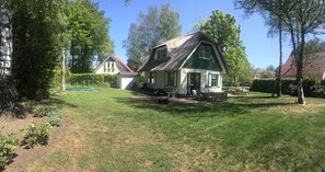 A house with a green roof, a lawn, and a small garden area. - Holiday Home in Heeten Near Forest (Heeten)