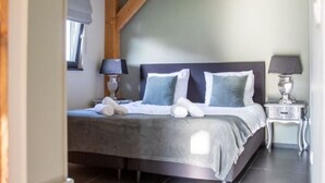 A neatly arranged bedroom with a bed, bedside tables, and a window with curtains. - Tranquil Holiday Home in Alphen-chaam With Stables (Alphen)