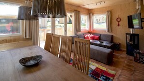 A wooden interior with a dining table, chairs, a sofa, and a TV. - Awe-inspiring Chalet Near Ski Area in Sankt Georgen ob Murau (Sankt Georgen am Kreischberg)