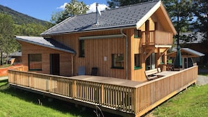 A wooden cabin with a deck, large windows, and a chimney. - Awe-inspiring Chalet Near Ski Area in Sankt Georgen ob Murau (Sankt Georgen am Kreischberg)