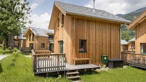Una fila di cabine in legno con veranda, finestra e camino.