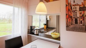 Una cocina moderna con una ventana, una cafetera, un hervidor y un tazón sobre la encimera.