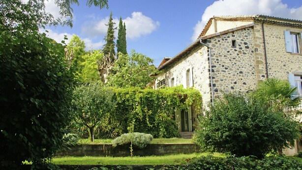 A stone building with a garden, a pathway, and a small door. - Holiday Home in Ardeche Near Chateau Ventadour (Lalevade-d'Ardeche)