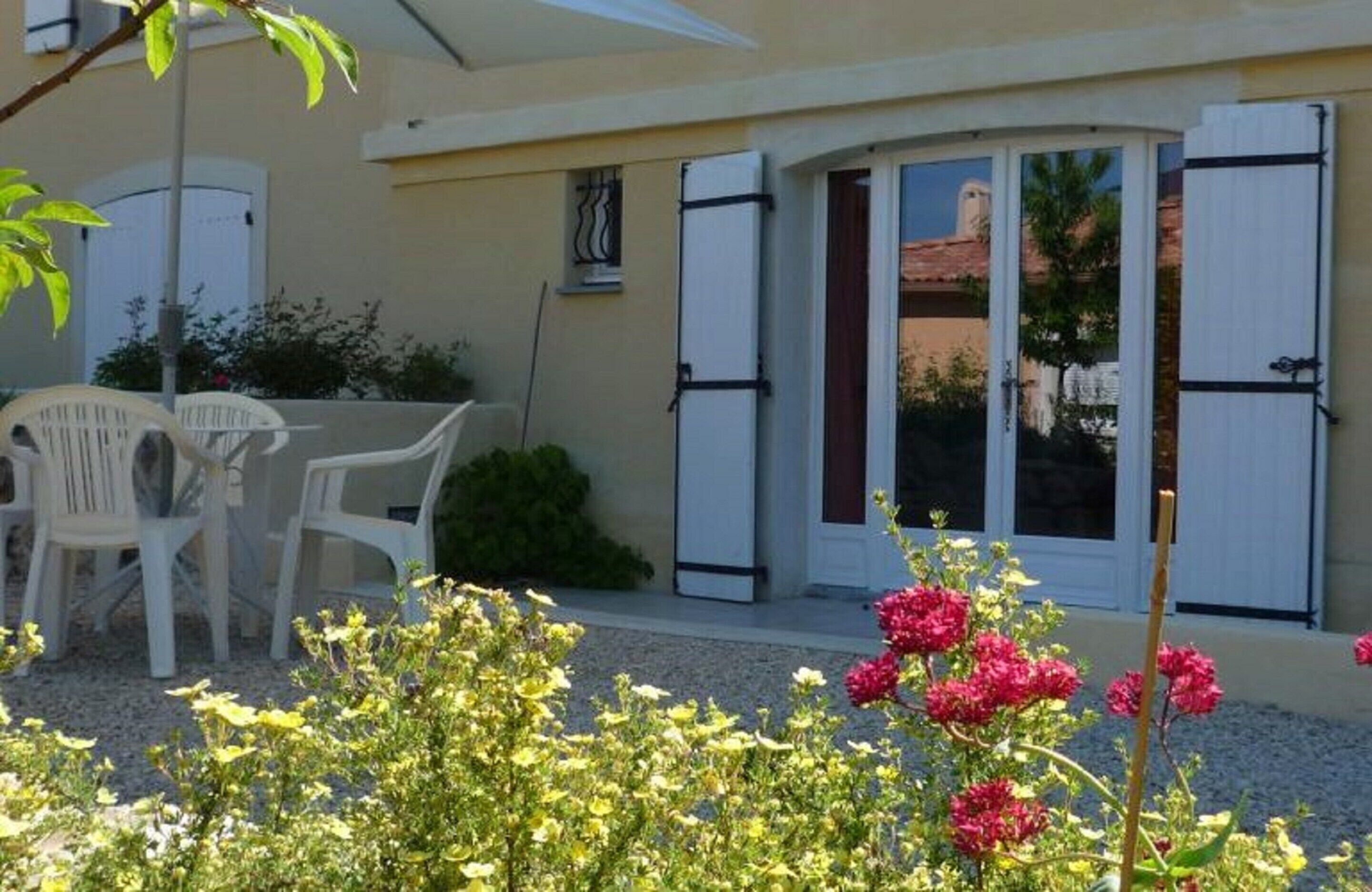 A building with a patio area, white shutters, and a door with glass panels.