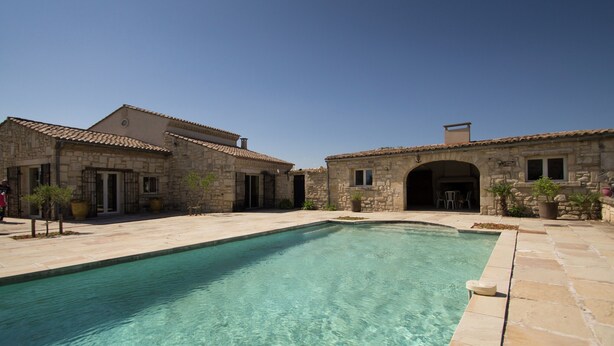 A stone building with a swimming pool, clear water, and a patio area. - Vineyard Villa in Montfrin (Montfrin)