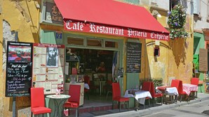 A café restaurant with outdoor seating, a red awning, and a menu board. - Vineyard Villa in Montfrin (Montfrin)