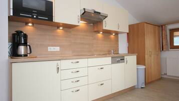 Una cocina moderna con electrodomésticos integrados, armarios de madera e iluminación debajo de los armarios.