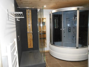 A modern bathroom with a glass-enclosed shower, a wooden door, and a white sink. - Villa in Ayguatebia-talau With Garden & BBQ (Ayguatebia-Talau)