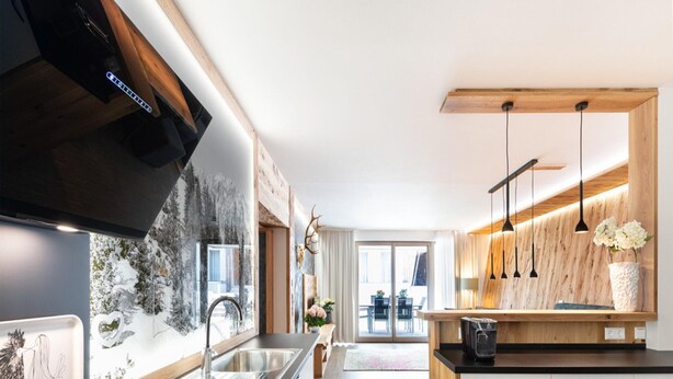Cocina moderna con una isla grande, electrodomésticos de acero inoxidable y detalles de madera.