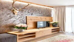 Una sala de estar moderna con un mueble de entretenimiento de madera, un televisor montado y una decoración de astas.