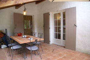 A dining area with a table, chairs, and a hanging light fixture. - Holiday Home Montaigu-de-quercy Lake (Montaigu-de-Quercy)